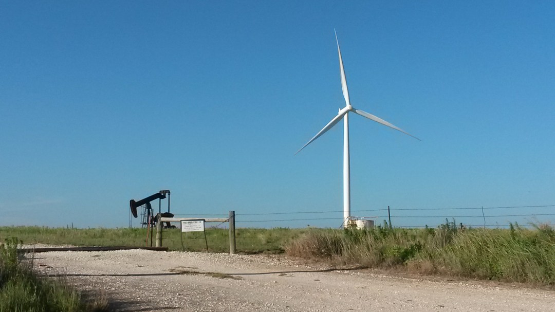 A wind turbine and petroleum pump, side by side